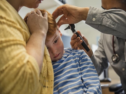 a child getting his ear examined at the doctor's office